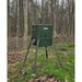 American Feeder AF300 300 lb Scatter Feeder standing on tripod legs in a springtime forest with solar panel mounted on a leg