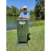 Bill Dance standing beside the American Feeder H125 Lake Feeder on a grassy bank next to a calm pond