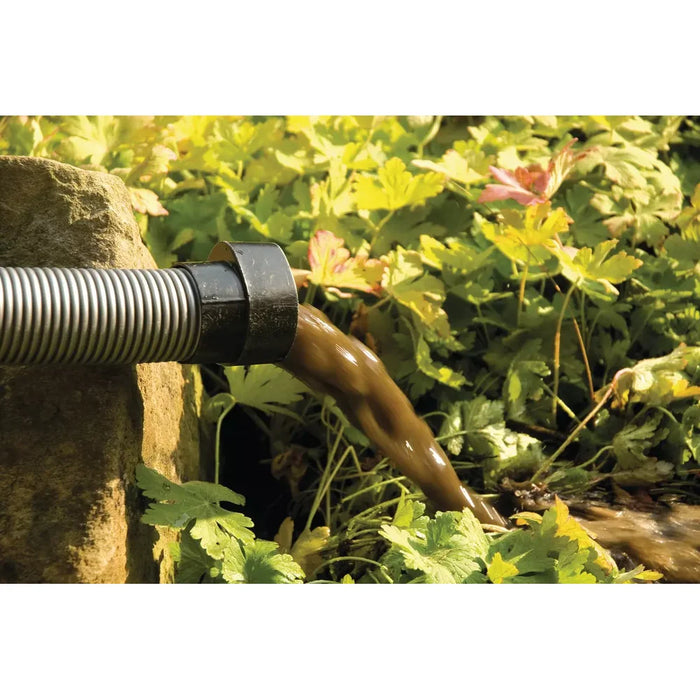 Discharge hose of the OASE PondoVac 4 sludge vacuum releasing brown waste water into a flower bed as organic fertiliser