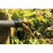 Discharge hose of the OASE PondoVac 4 sludge vacuum releasing brown waste water into a flower bed as organic fertiliser