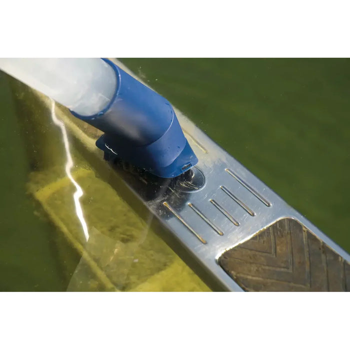 Underwater close-up of the oase PondoVac 4 blue brush nozzle cleaning a ridged pool floor beneath green tinted water