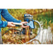 Person fitting the wide flat squeegee nozzle to the pole of the Oase PondoVac 5 Sludge Vacuum near a pond