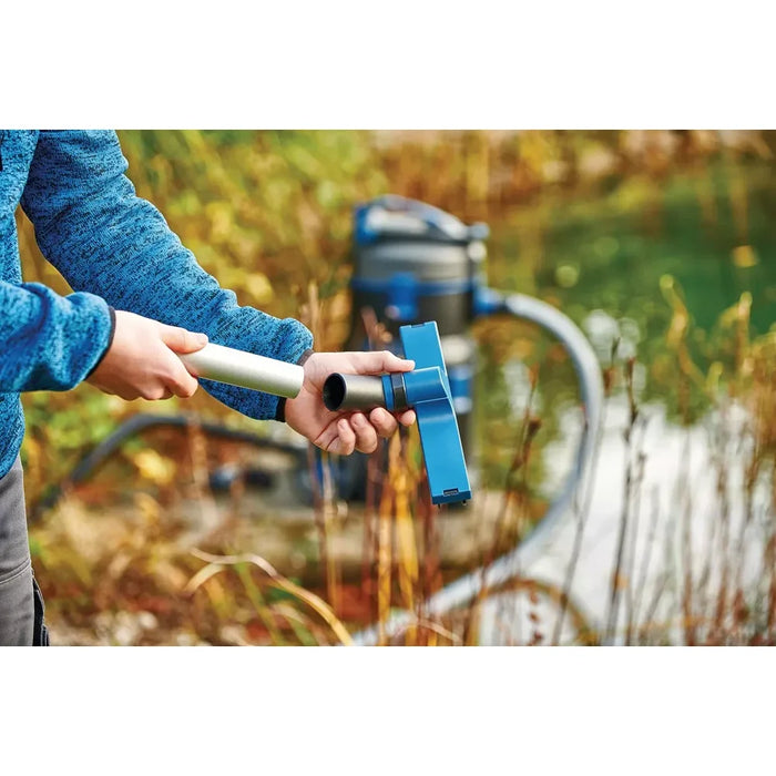 Person fitting the wide blue universal floor nozzle to the Oase PondoVac 5 pole beside a pond