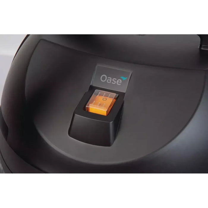 Close-up of the Oase PondoVac Classic pond vac illuminated orange rocker switch and branding on the motor unit lid