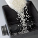 Pouring white bio-media into the open tank of the Oase ProfiClear Premium Moving Bed Module Bio Filter