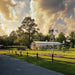 Outdoor Water Solutions Steel Tower Windmill Pond Aerator on a landscaped property with white barn and wood fence