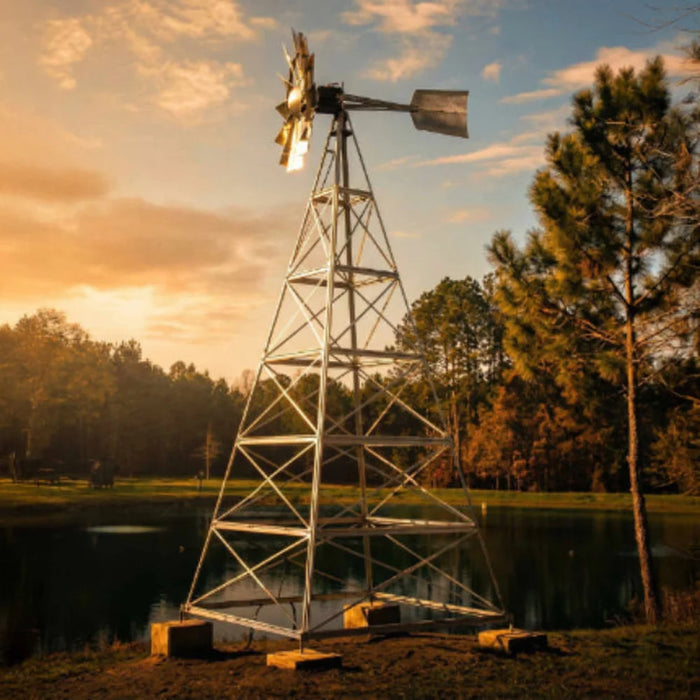 Outdoor Water Solutions Steel Tower Windmill Pond Aerator galvanized 4 leg tower beside a pond at golden hour