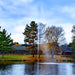 scott_aerator_jet_stream_pond_fountain_in_water_with_building_and_trees_in_background