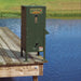 Texas Hunter Solar Fish Feeder for Ponds mounted on a wooden dock corner over water with feed window full of pellets
